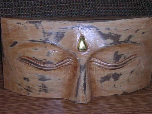 wooden plaque of buddha's eyes